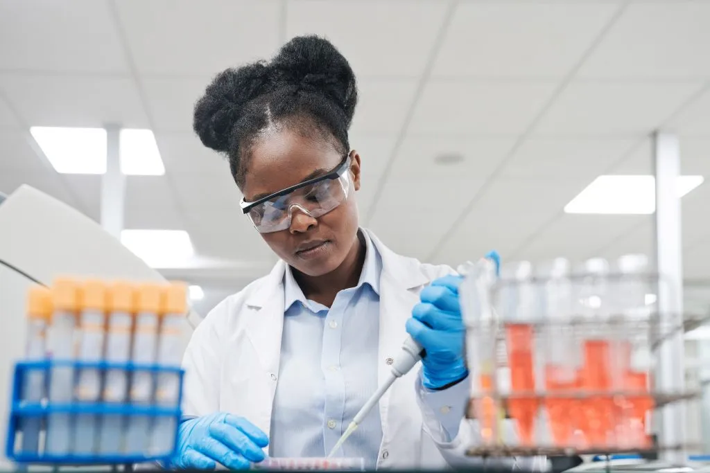 black female scientist using pipette